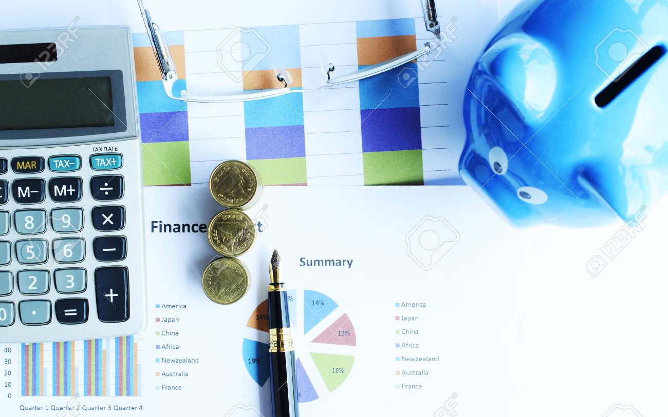 Financial concept with money coins stack and business fountain pen and calculator and eyeglasses and blue piggy bank labtop with document chart on desk office backgrounds above